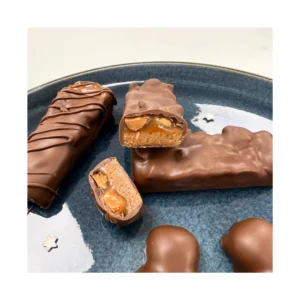 Atelier pâtisserie parent-enfant autour du Snickers : vous réalisez en duo (un adulte et un enfant) des barres chocolatées gourmandes avec caramel, cacahuètes et chocolat, dans une ambiance conviviale et ludique.